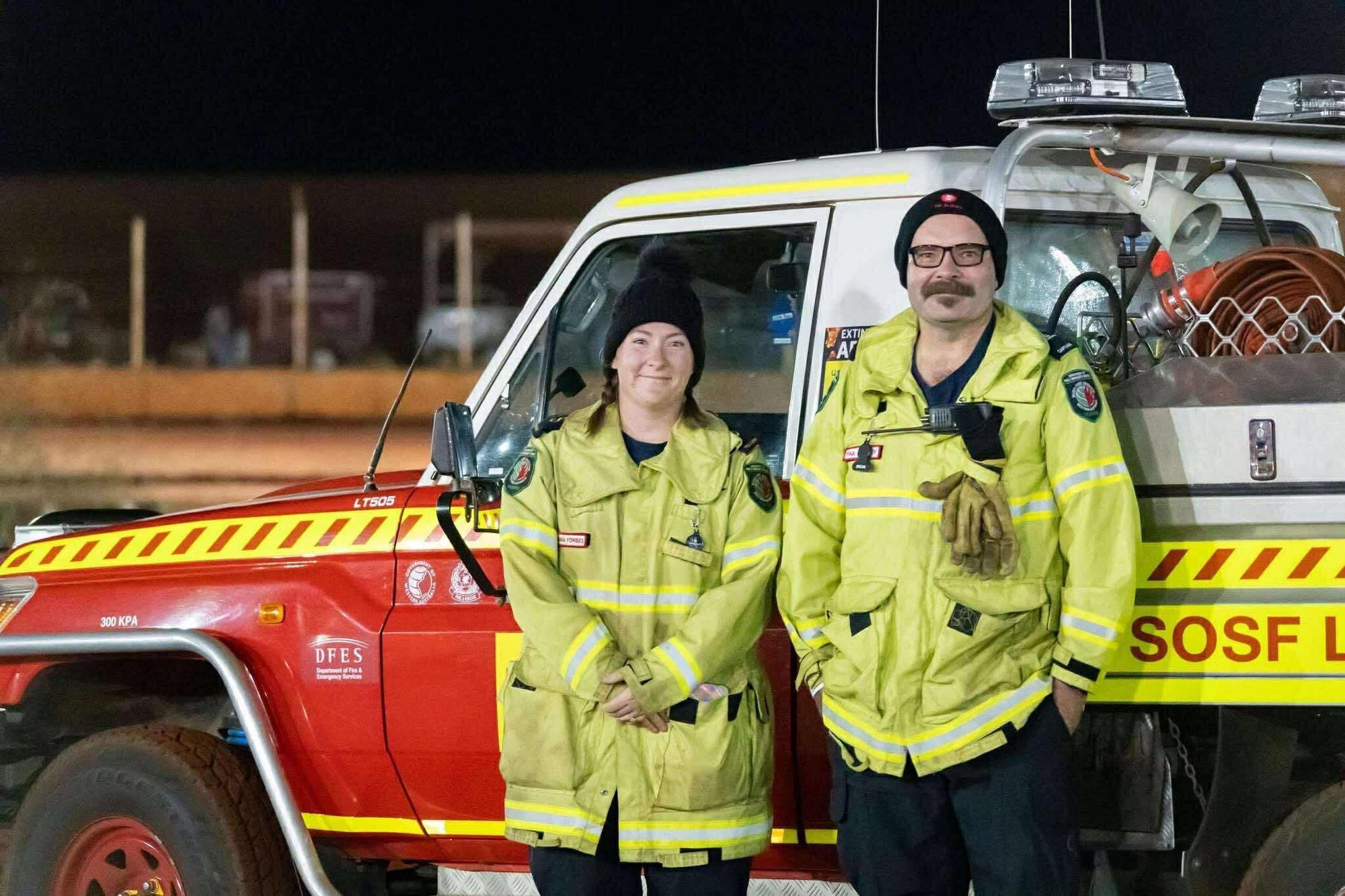 Two people in front of community fire engine